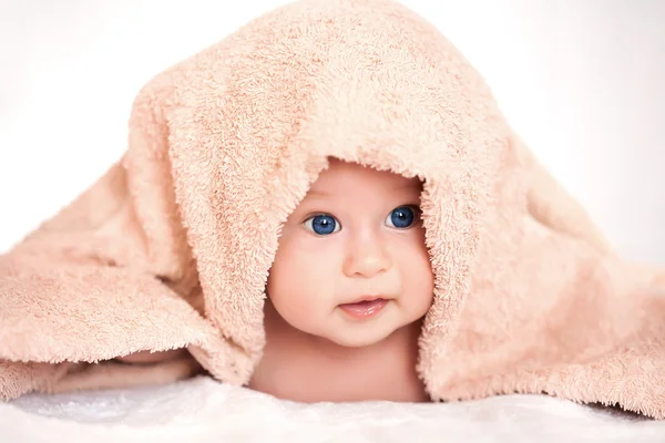 Meisje van de baby is verstopt onder de handdoek beige terry — Stockfoto