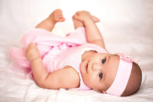 Schattig baby meisje in een roze jurk — Stockfoto