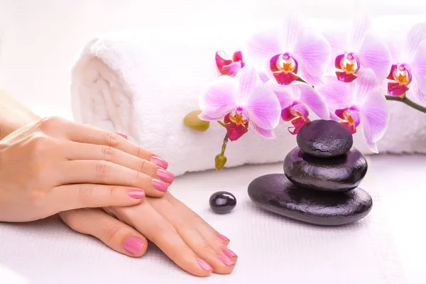 Bela manicure com orquídea rosa e toalha — Fotografia de Stock