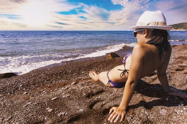 Happy smiling girl is sunbathing on a beach — Stock fotografie
