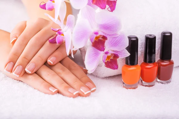 Mooie manicure met roze orchid op de witte — Stockfoto