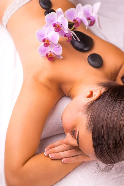 Woman in spa salon with hot stones — Stock Photo, Image