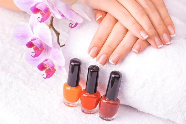 Manicura francesa con orquídea rosa sobre el blanco — Foto de Stock