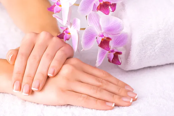 Bella manicure con orchidea rosa sul bianco — Foto Stock