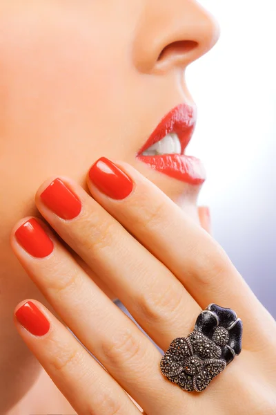 Face and beautiful red manicure on the blue — Stock Photo, Image