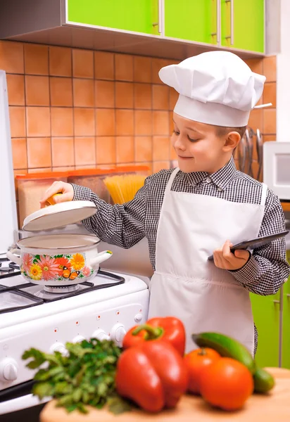 Fiú szakács főzés a konyhában — Stock Fotó