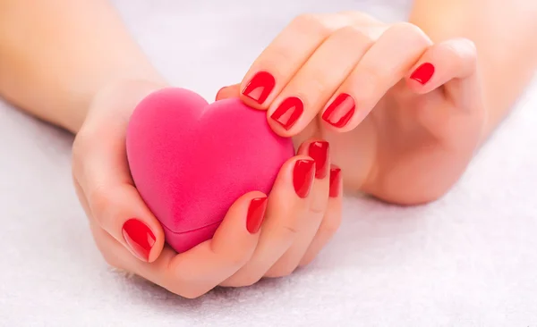 Red manicure with gift box on the white towel — Stock Photo, Image