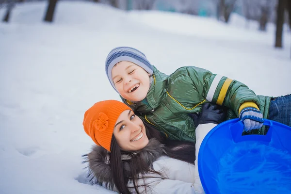 幸せな母と息子は雪の上を再生 — ストック写真