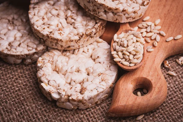 Pan crujiente, galletas de cereales y cuchara de madera con grano — Foto de Stock