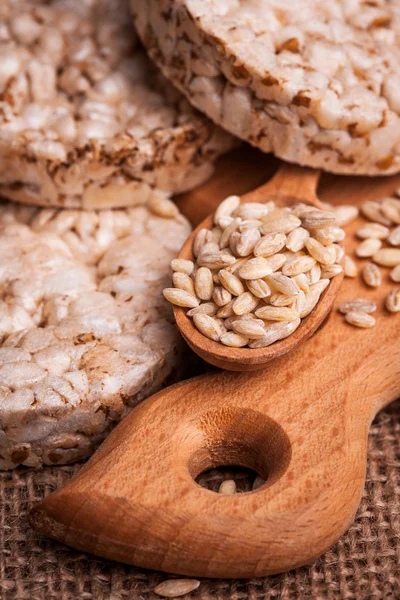 Pane croccante, cracker di cereali e cucchiaio di legno con grano — Foto Stock
