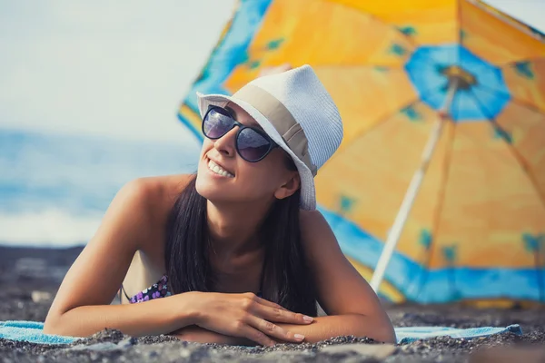 Menina bonita está tomando sol na praia — Fotografia de Stock