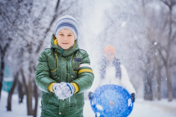 Gelukkig moeder en zoon spelen met sneeuw — Stockfoto