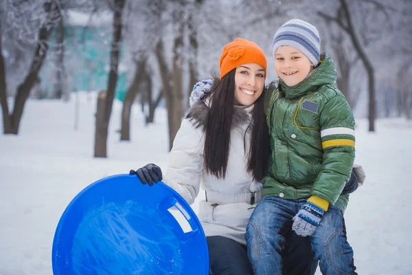 Feliz madre e hijo están jugando con la nieve — Foto de Stock