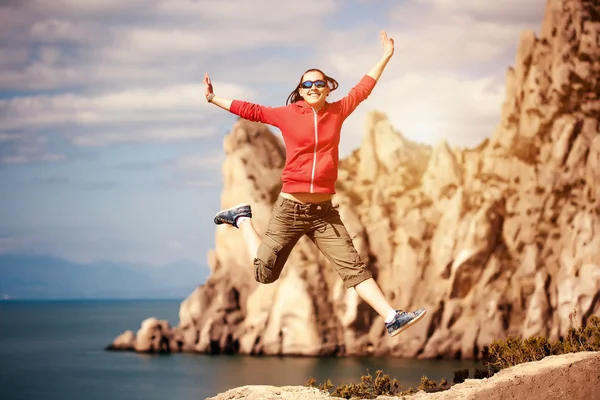 Girl jumping on rock — Stock Photo, Image