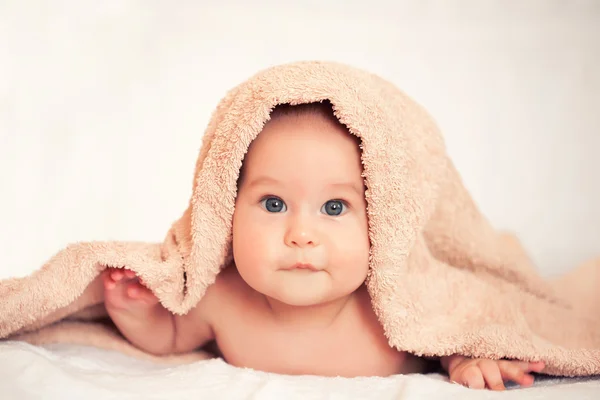 Baby girl is hiding under the white blanket — Stock Photo, Image