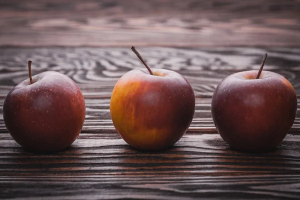 Red apples on wooden table, selective focus — Stock Photo, Image