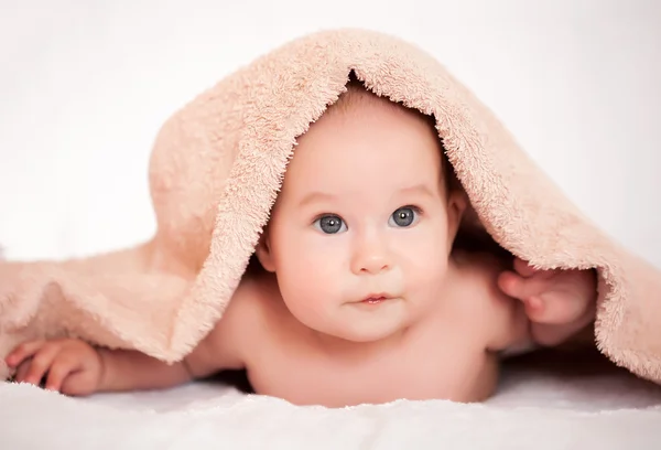 Küçük kız beyaz battaniyenin altında saklanıyor. — Stok fotoğraf