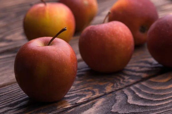 Red apples on wooden table, selective focus — Stock Photo, Image