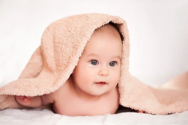 Baby girl is hiding under the white blanket — Stock Photo, Image