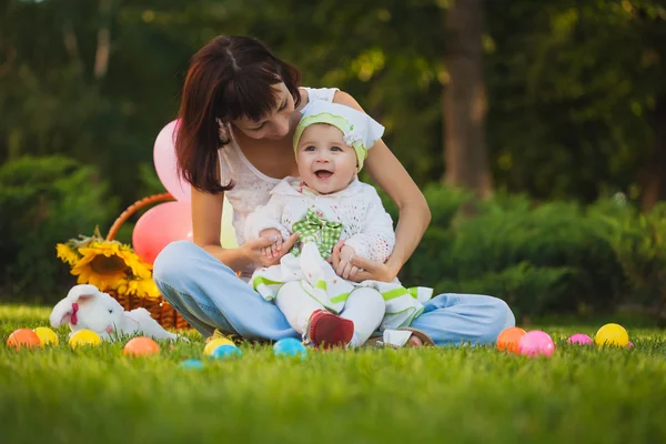 Baby en moeder spelen in het groene park — Stockfoto