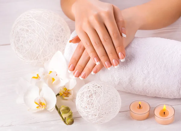 Mooie handen met manicure en wnite orchid bloem — Stockfoto