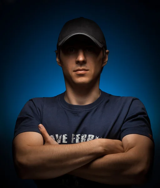 Knappe man draagt een pet op een blauw — Stockfoto