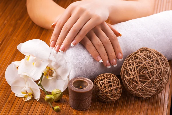 French manicure with white orchid  on a bamboo — Stock Photo, Image