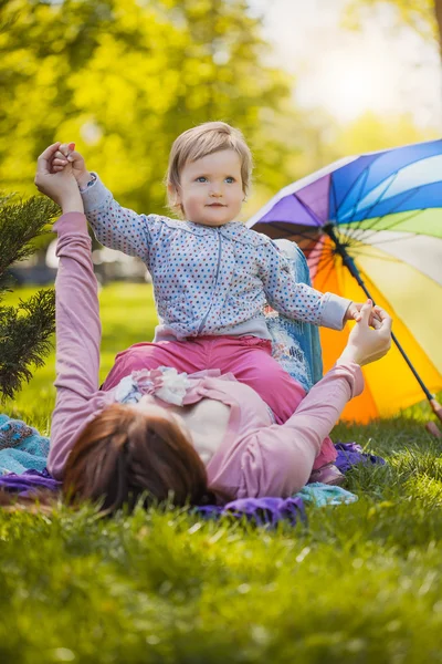 Happy mother and baby are laying on meadow — Stock Photo, Image