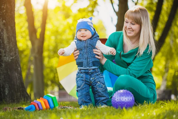 Mutlu anne ve bebek çayır üzerinde — Stok fotoğraf