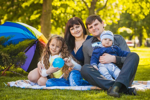 Счастливая семья косит в парке — стоковое фото