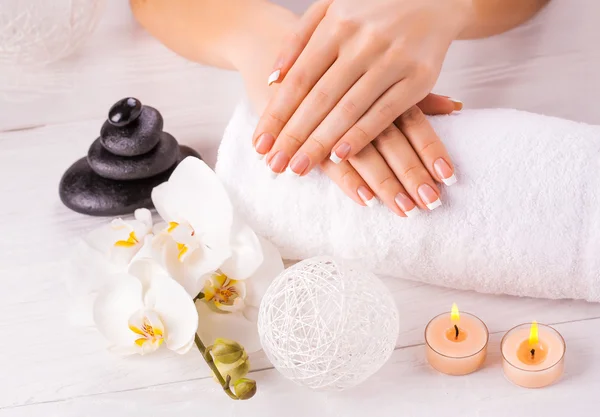 Manicura francesa y flor de orquídea wnite —  Fotos de Stock