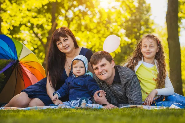 Une famille heureuse s'installe dans le parc — Photo
