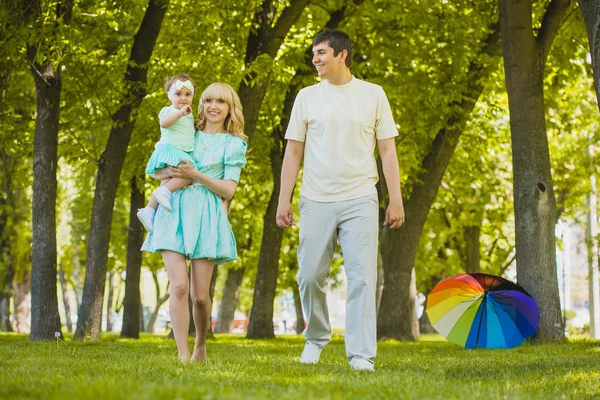 Glad ung familj spendera tid i solig park — Stockfoto