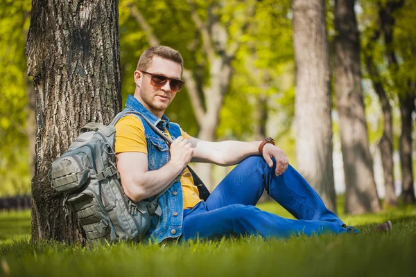 Man zit op het groene gras in park — Stockfoto