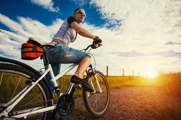 Frau mit Fahrrad im Feld — Stockfoto