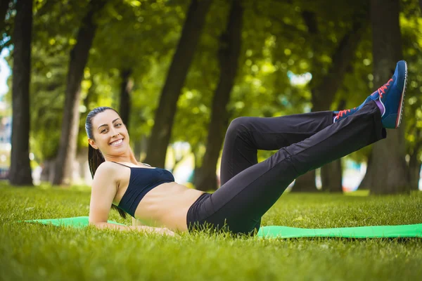 Ładna kobieta robi ćwiczenia w parku — Zdjęcie stockowe
