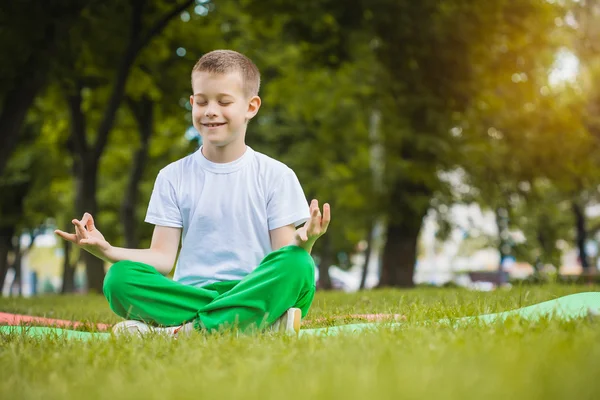 Niño feliz está haciendo ejercicios en el parque — Foto de Stock