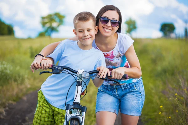 Mutter und Sohn mit Fahrrad im Feld — Stockfoto