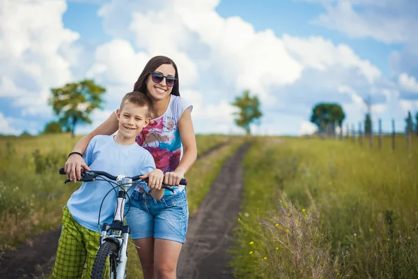 Mãe e filho andar de bicicleta no campo — Fotografia de Stock