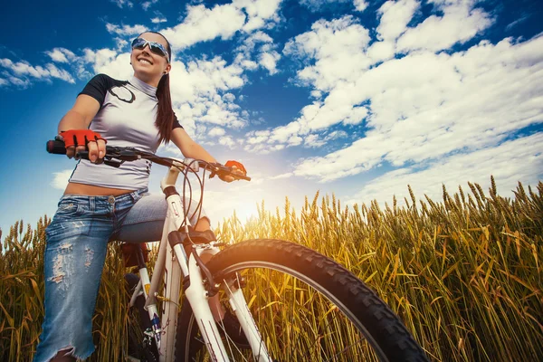 Kobieta jest jazda rowerem poza pole — Zdjęcie stockowe