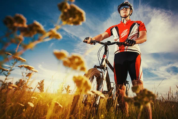 Man is riding bicycle outside in the field — Stock Photo, Image