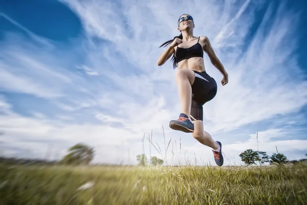 Ung kvinna joggar i naturen — Stockfoto