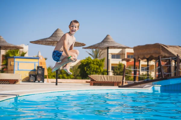Kid swimming and jumping in pool. summertime — Stock Photo, Image