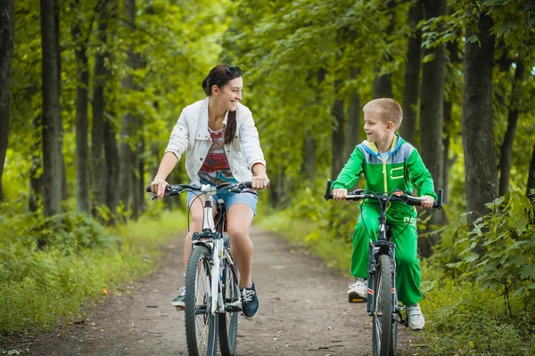 Familia feliz. madre e hijo cabalgando en el parque — Foto de Stock