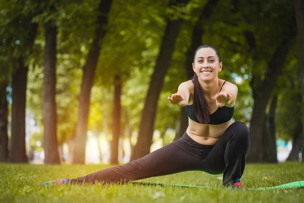 Pretty woman doing exercises in the park — Stock Photo, Image