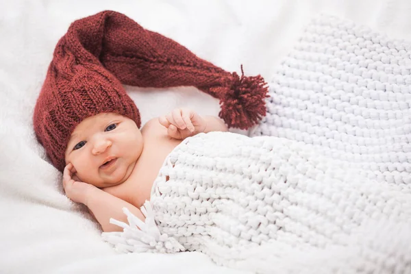 Beyaz arka planda örülmüş şapkalı şirin yeni doğmuş bebek kız. — Stok fotoğraf