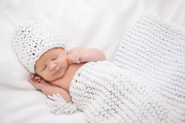 Schattig pasgeboren baby meisje in een gebreide muts op de witte rug — Stockfoto