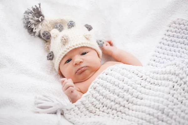 Niedliches neugeborenes Mädchen mit Strickmütze auf dem weißen Hinterhof — Stockfoto