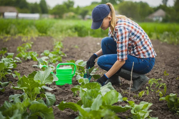 Kvinna bonde arbetar i en trädgård i en rutig skjorta. — Stockfoto