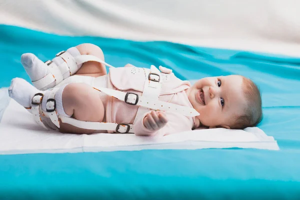 Een baby draagt een harnas die heupdysplasie corrigeert — Stockfoto